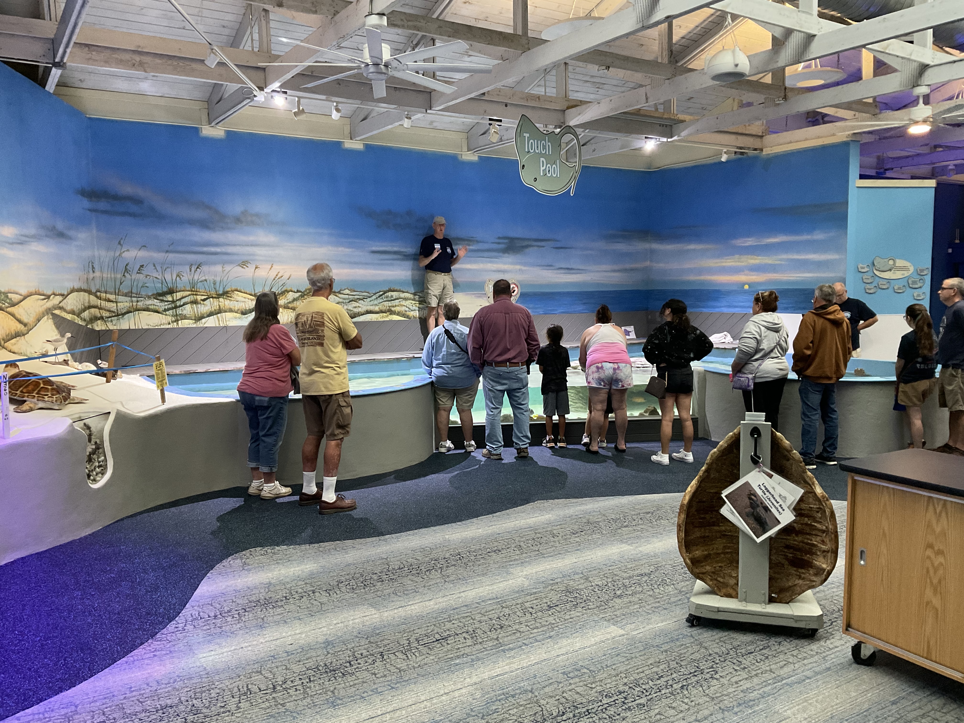 staff educating group of people about rays at the touch pool
